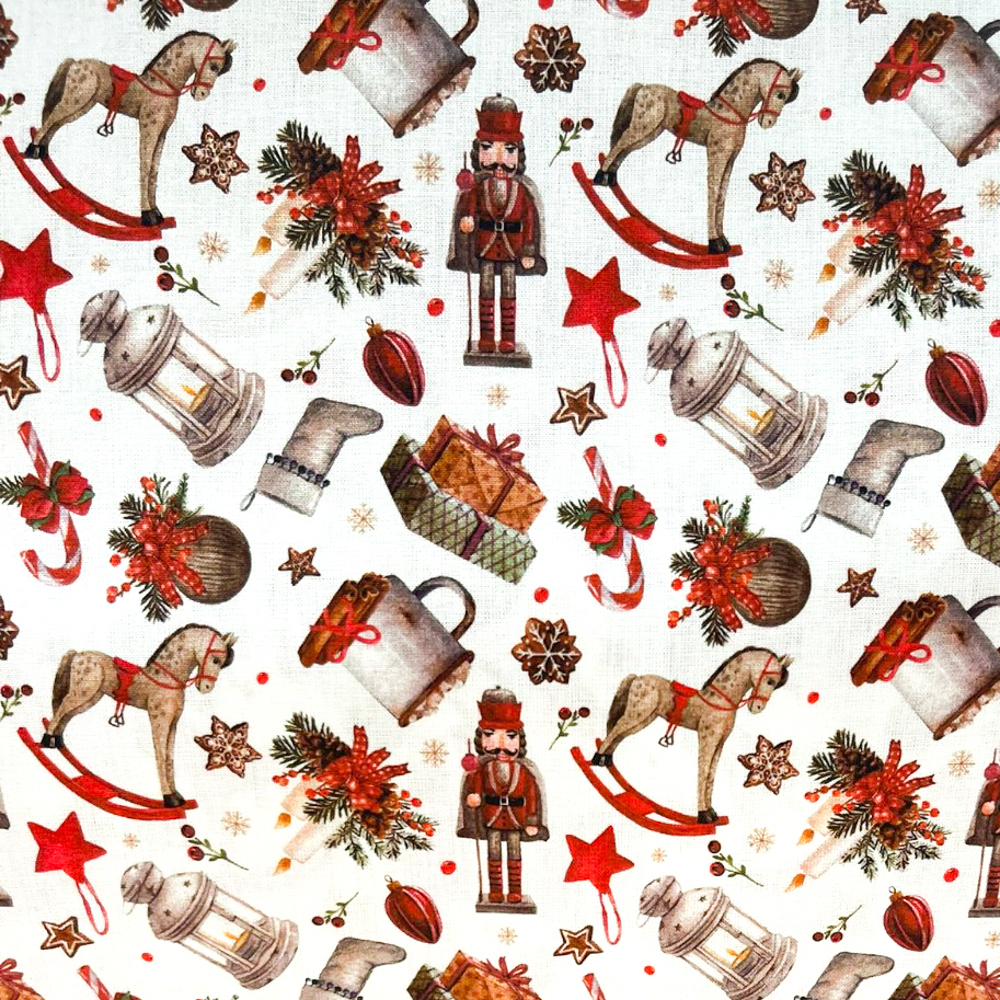 Stoff von nostalgischen Motiven: Spielzeugpferd, Laternen, Sterne und Weihnachtsdekoration auf weißem Hintergrund.