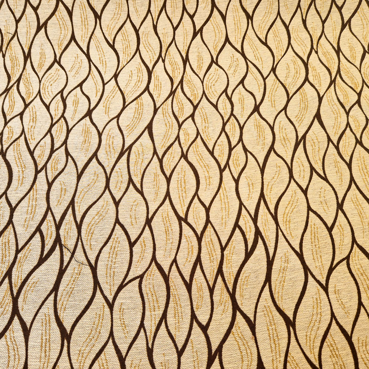 Stoff von wellenförmigem Muster in Braun auf hellem Hintergrund, mit geschwungenen Linien und Textur.