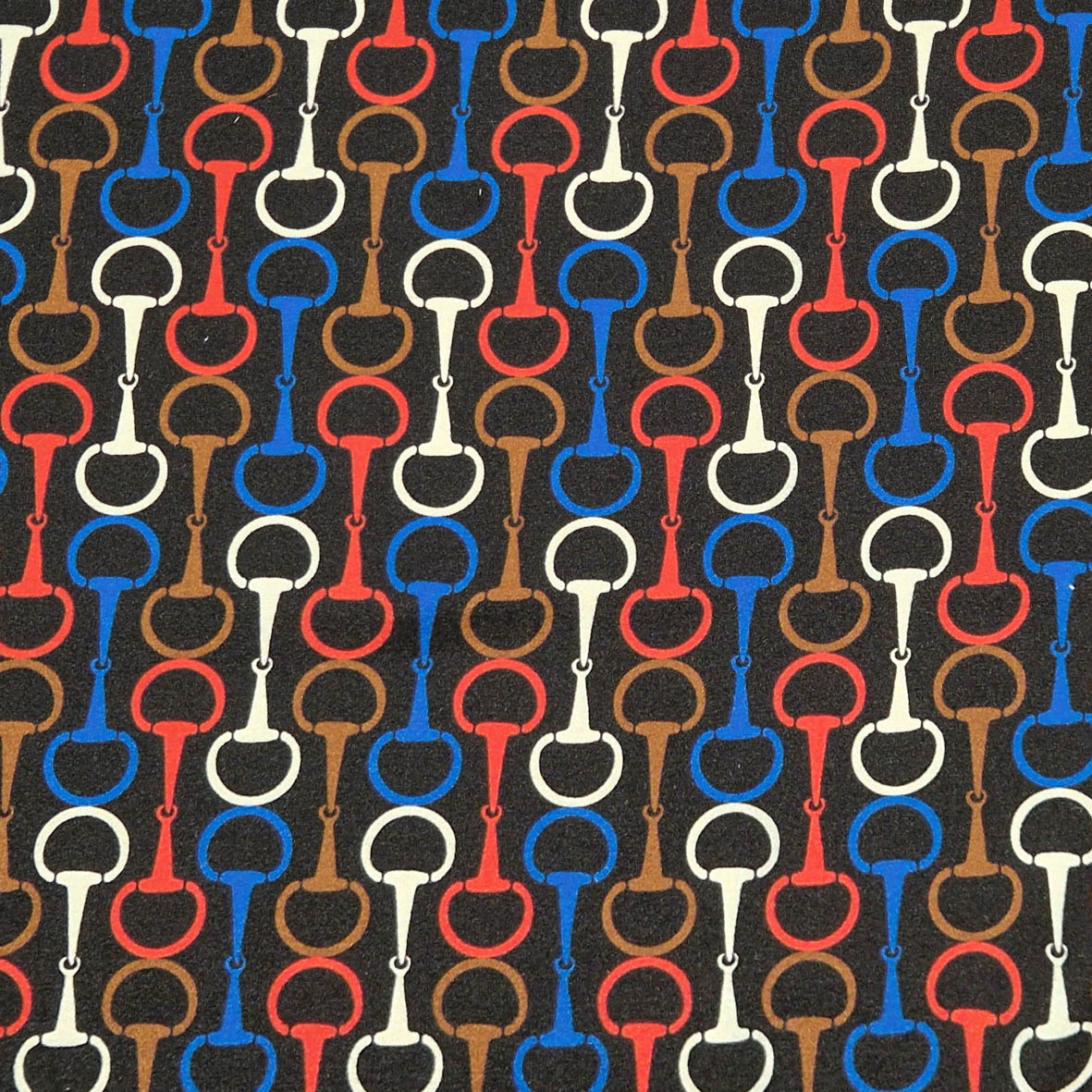 Stoff von bunten, geometrischen Mustern mit Hufeisen in Rot, Blau, Braun und Weiß auf schwarzem Hintergrund.