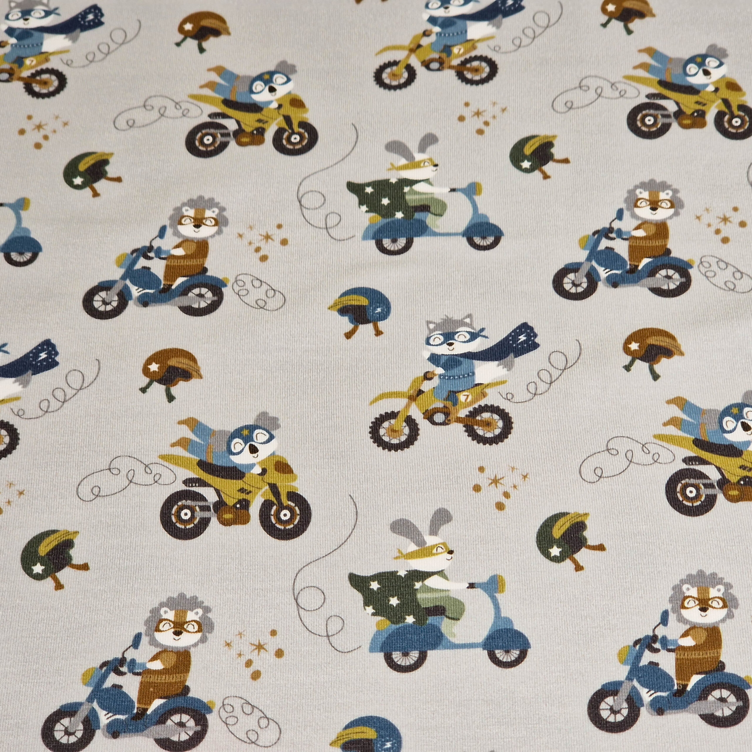 Stoff von einem hellen Hintergrund mit bunten Tiermotiven auf Motorrädern und Rollern.