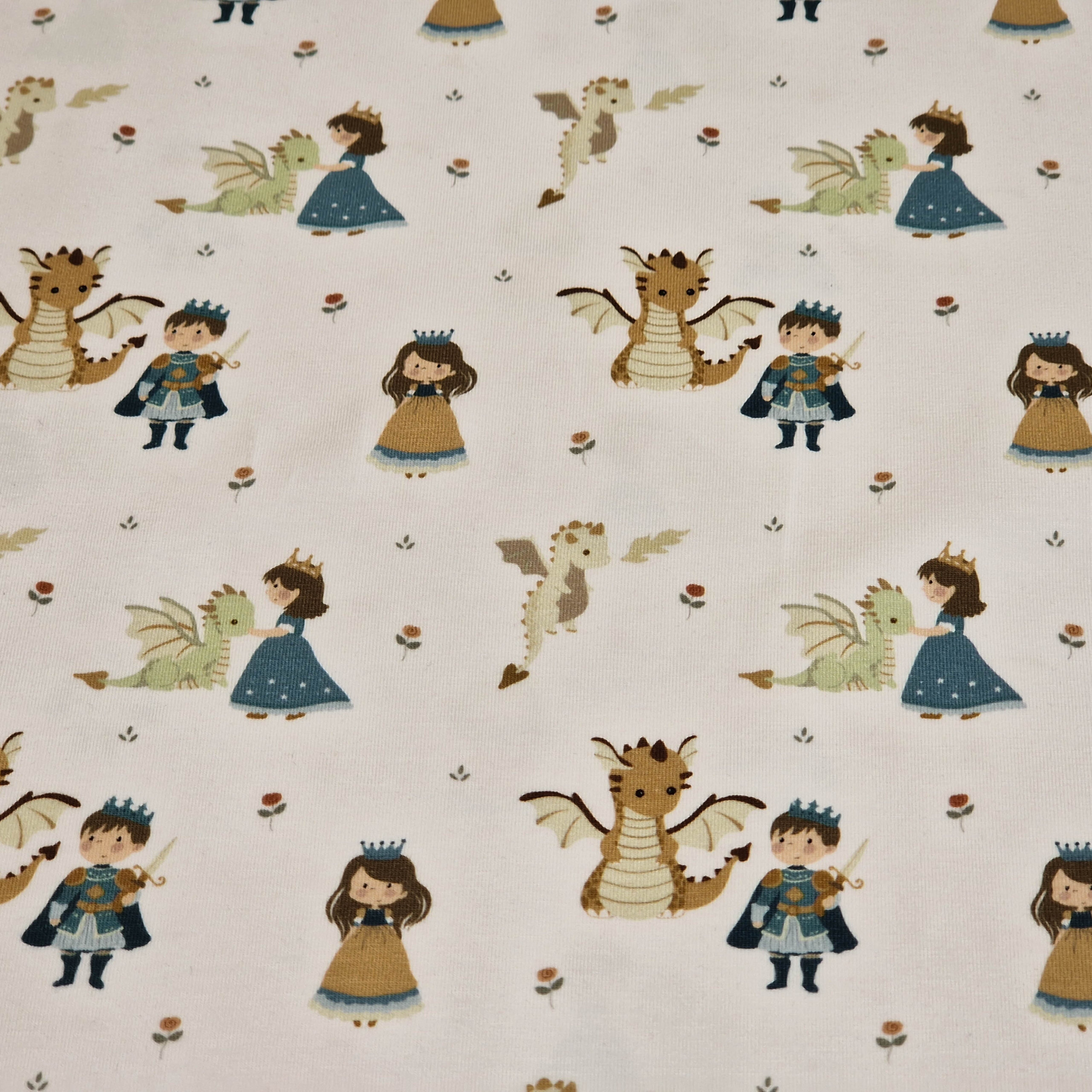 Stoff von Prinzen, Prinzessinnen und Drachen auf einem weißen Hintergrund mit Blumenmuster.
