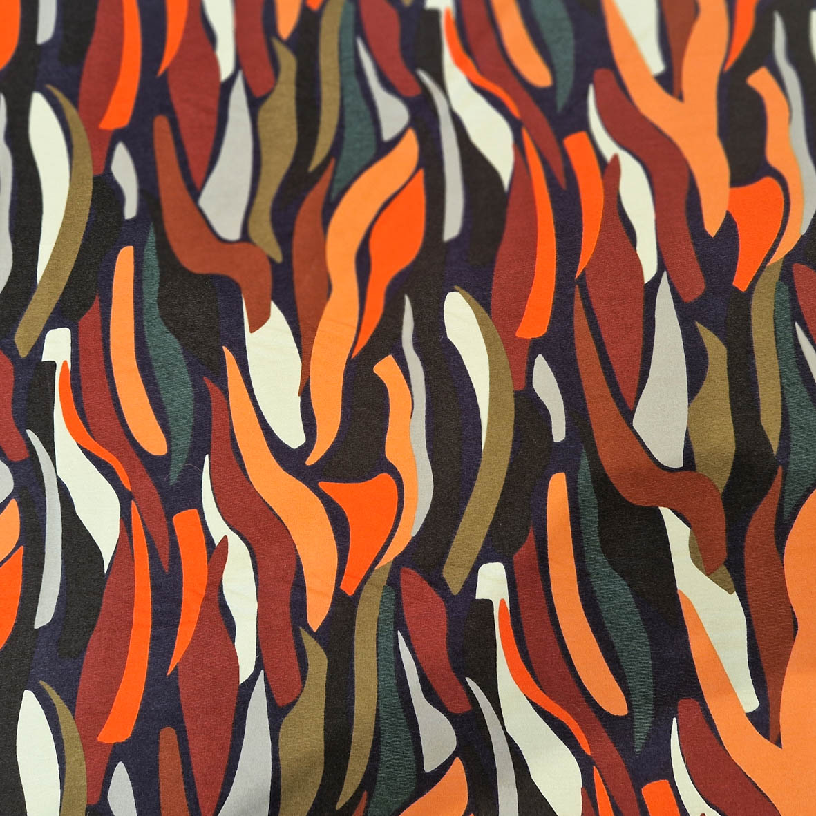 Stoff von bunten, geschwungenen Linien in Orange, Braun, Grün und Beige auf dunklem Hintergrund.